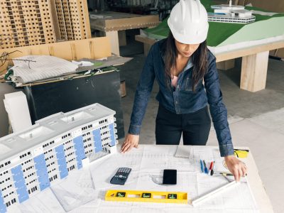 african-american-lady-safety-helmet-standing-near-model-building